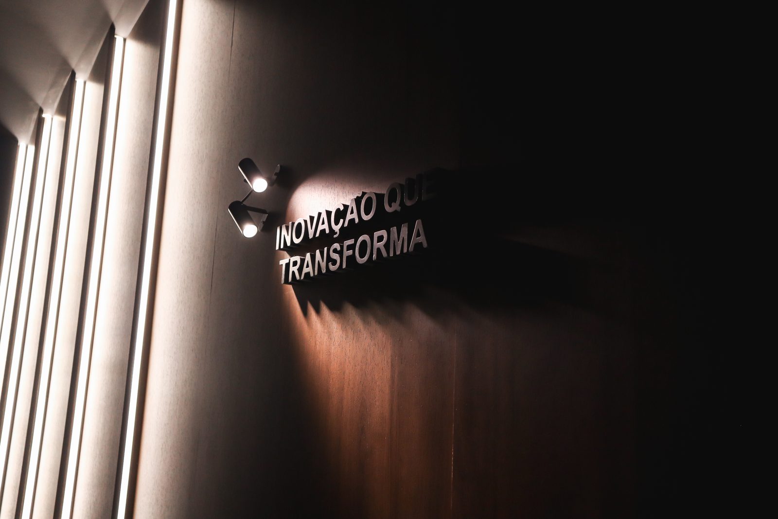 Painel de madeira iluminado com a frase Inovação que Transforma